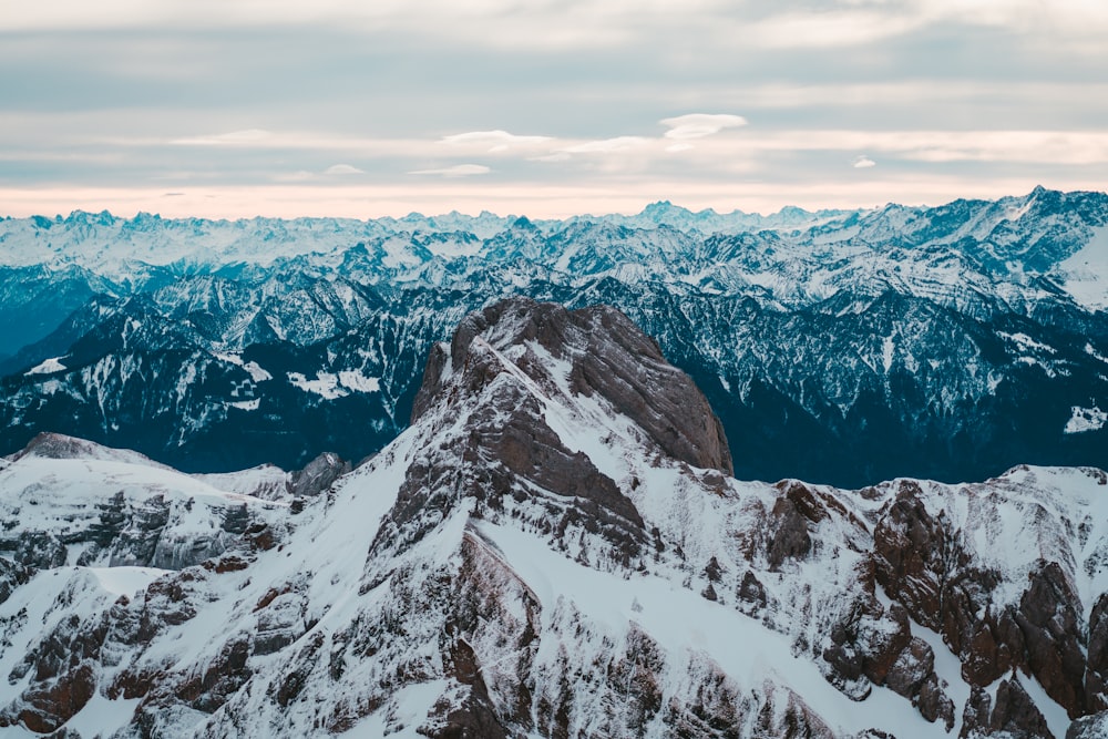 snow covered mountain under cloudy sky during daytime