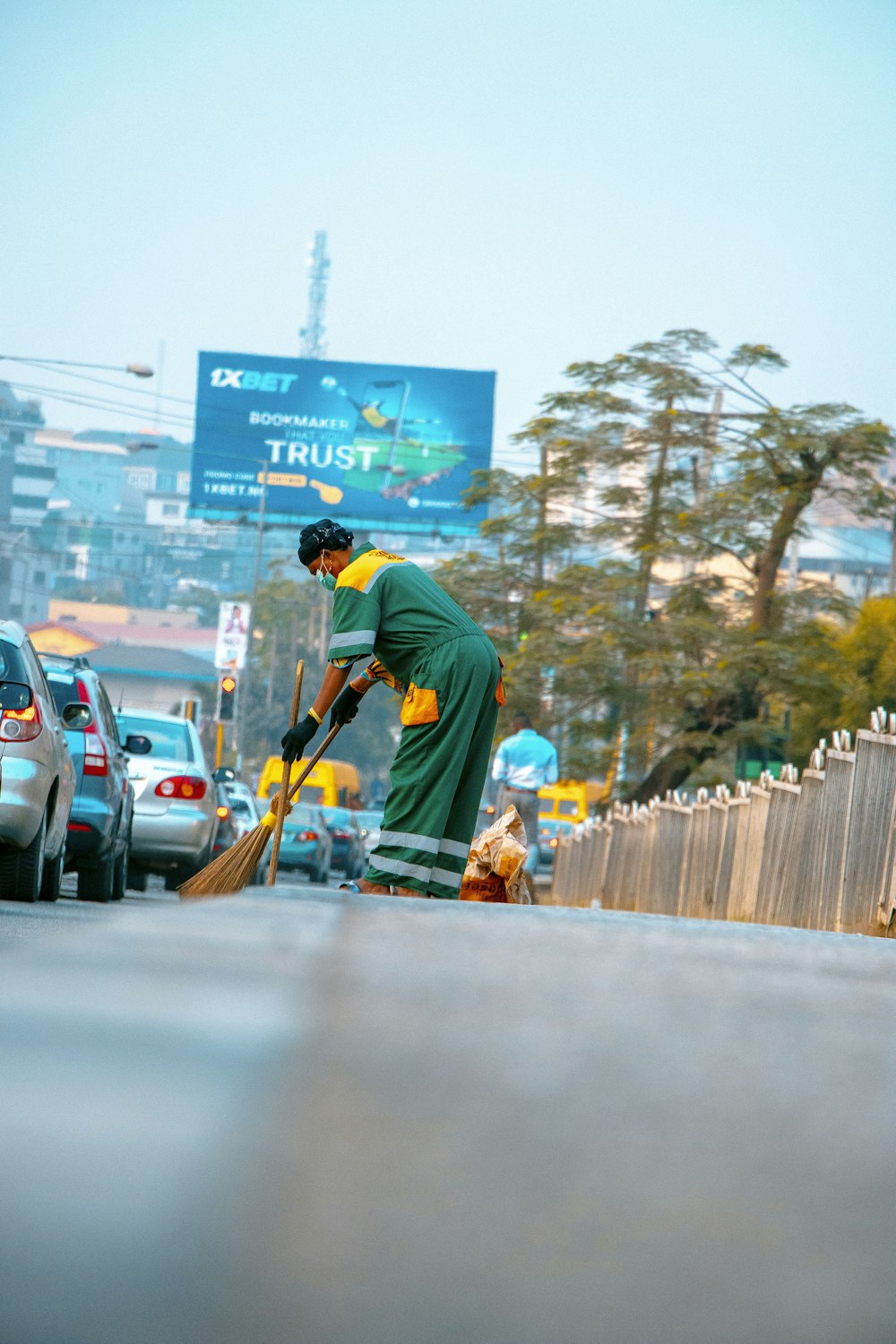 Hombre con camisa verde y pantalones naranjas caminando por la calle durante el día