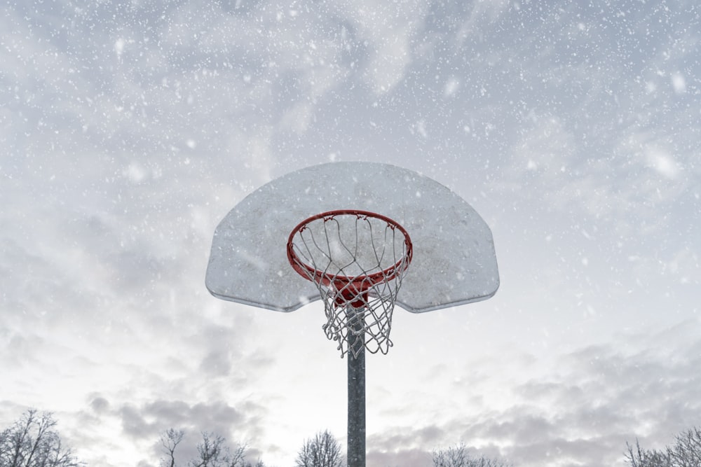 red and black basketball hoop under white clouds