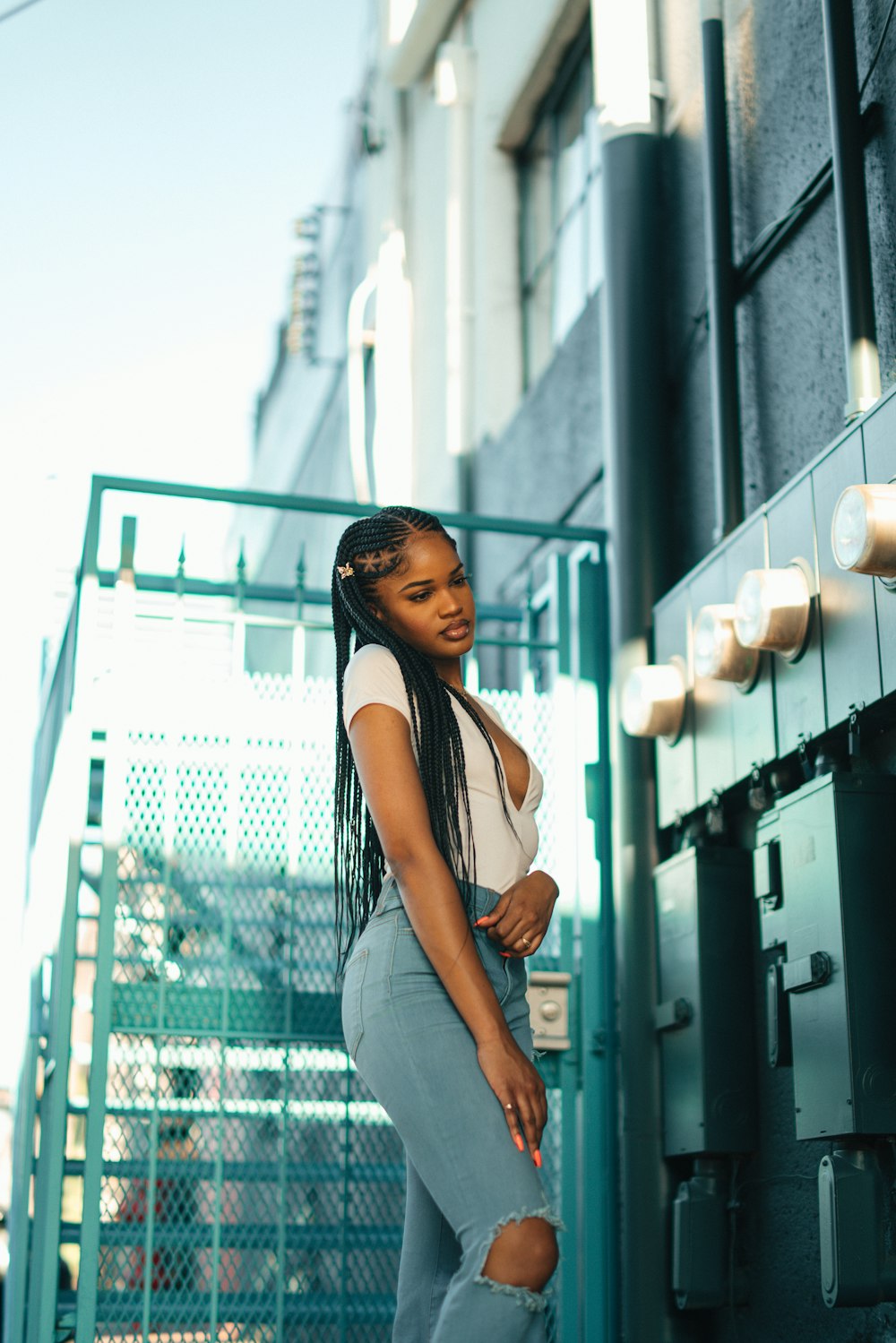 woman in blue denim jeans standing near glass window