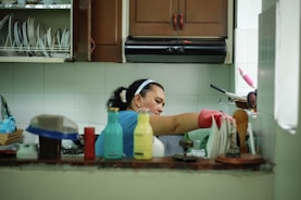 woman in white tank top holding white plastic container