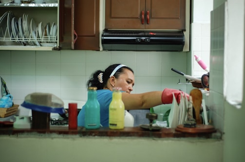 woman in white tank top holding white plastic container