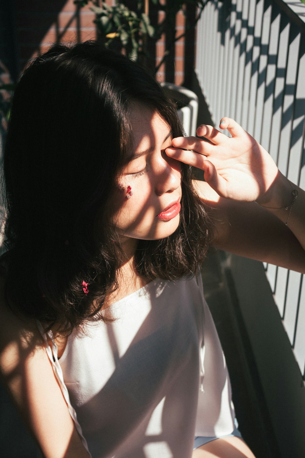 woman in white shirt holding her hair