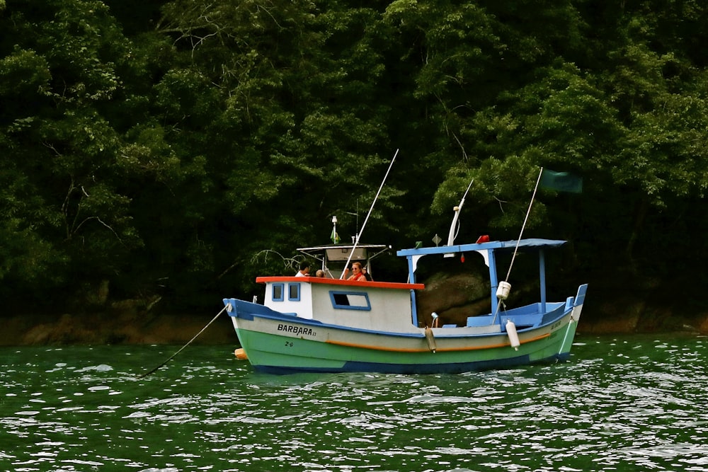 blue and white boat on body of water during daytime