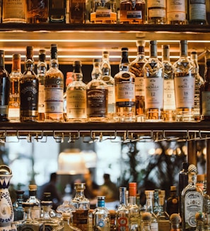 clear glass bottles on brown wooden shelf