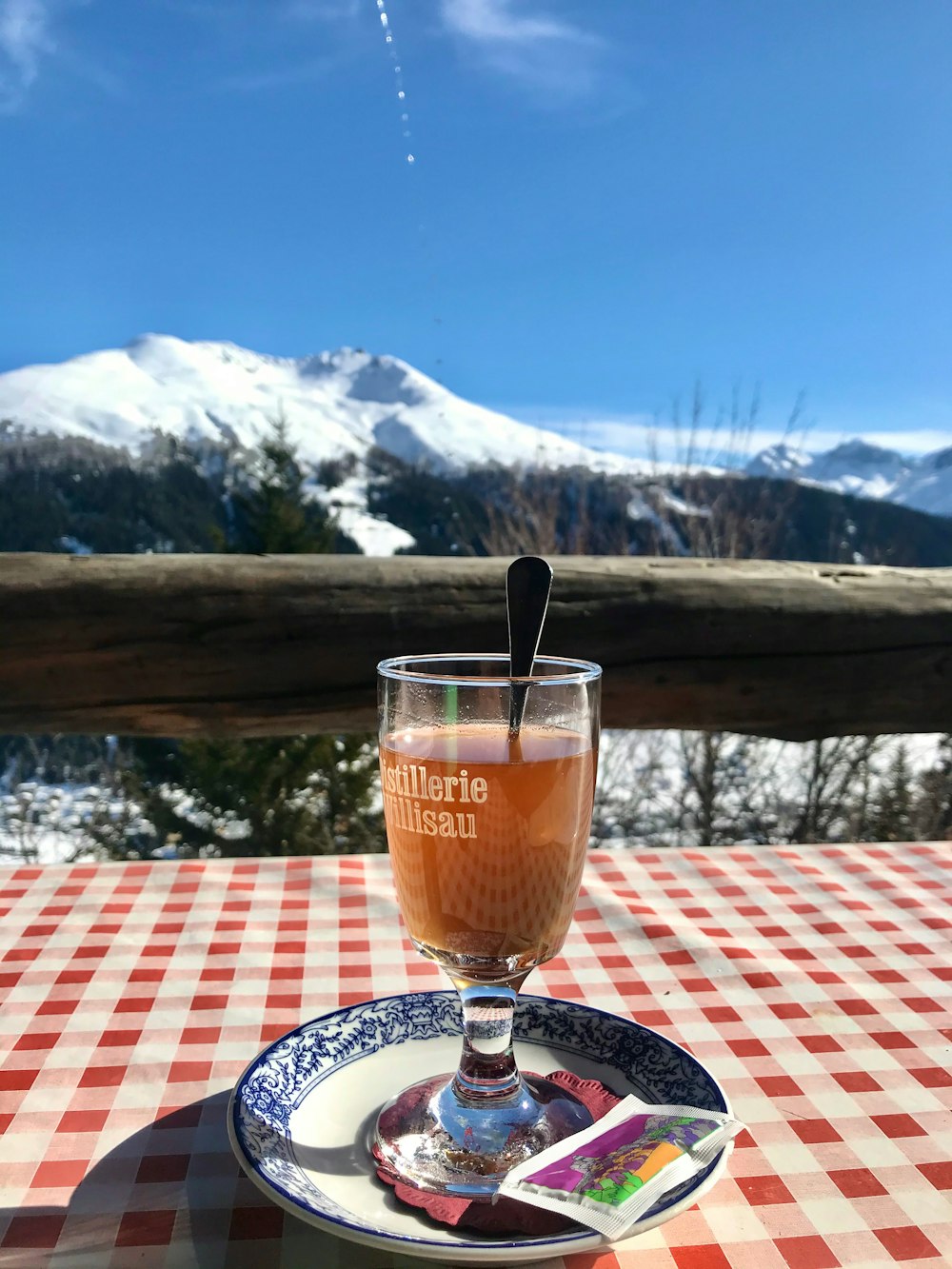 clear drinking glass with brown liquid on table