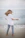 woman in white shirt and blue denim jeans standing on beach shore during daytime