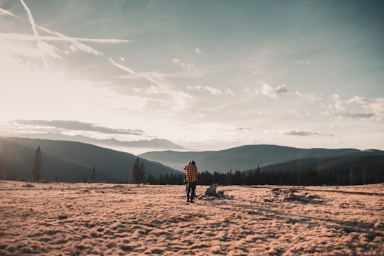 person in black jacket standing on brown field during daytime in Rogla Slovenia