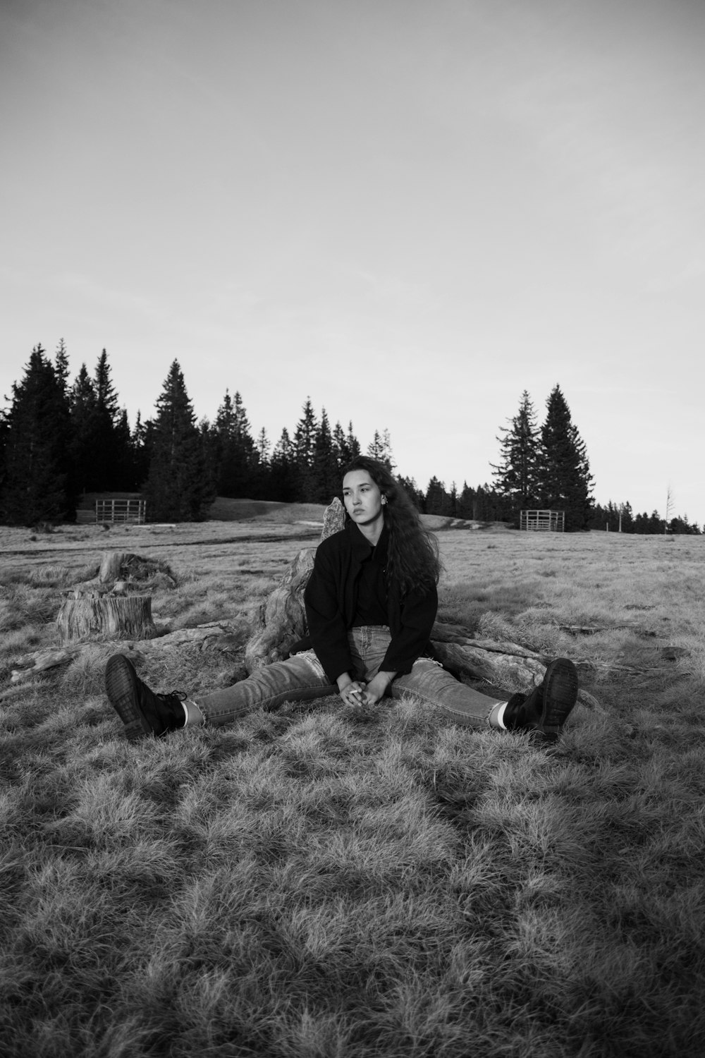 Photo en niveaux de gris de 2 femmes assises sur un terrain en herbe