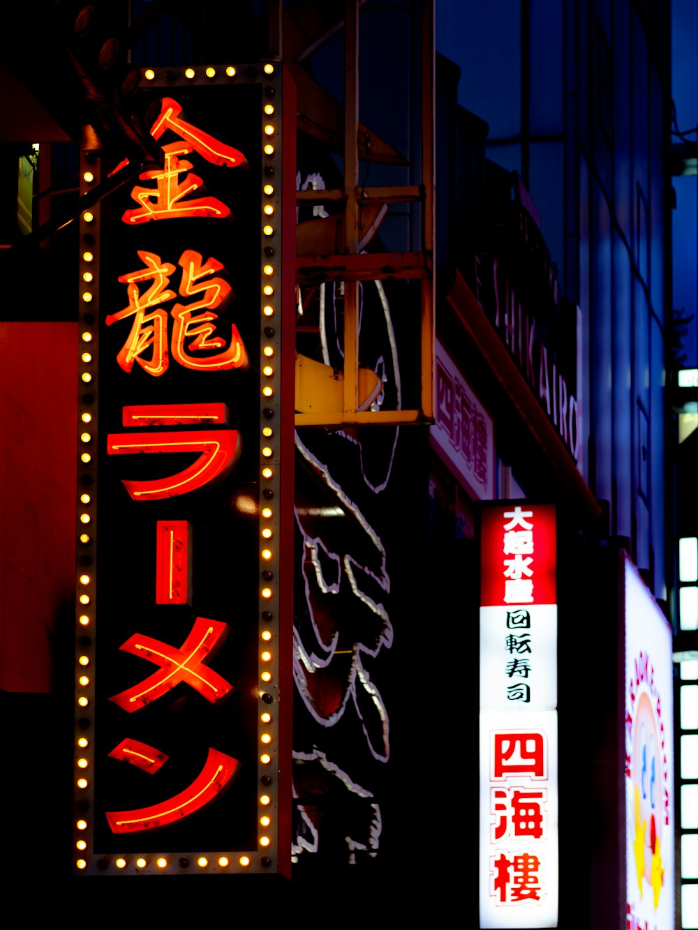 Señalización de luz de neón con texto kanji rojo y negro