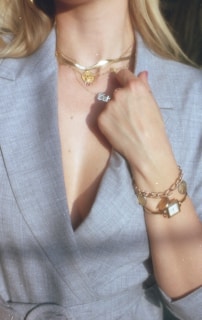 woman in gray blazer wearing gold bracelet and gold bracelet