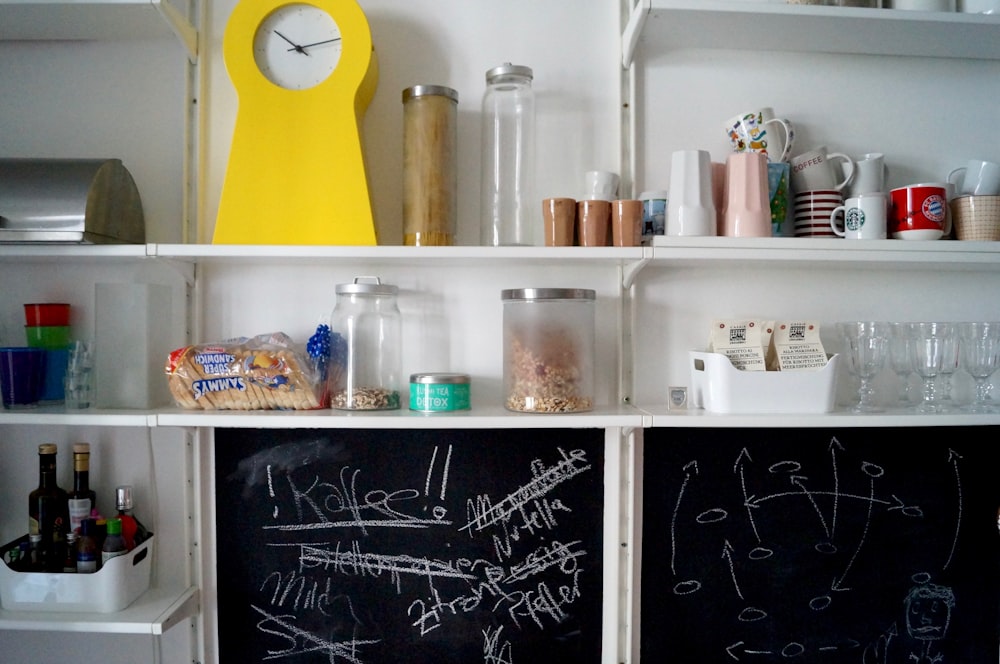 étagère en bois blanc avec bouteilles et bocaux