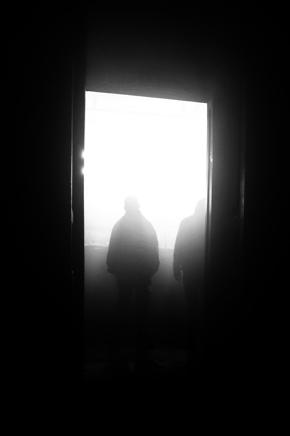 silhouette of man and woman standing in front of window