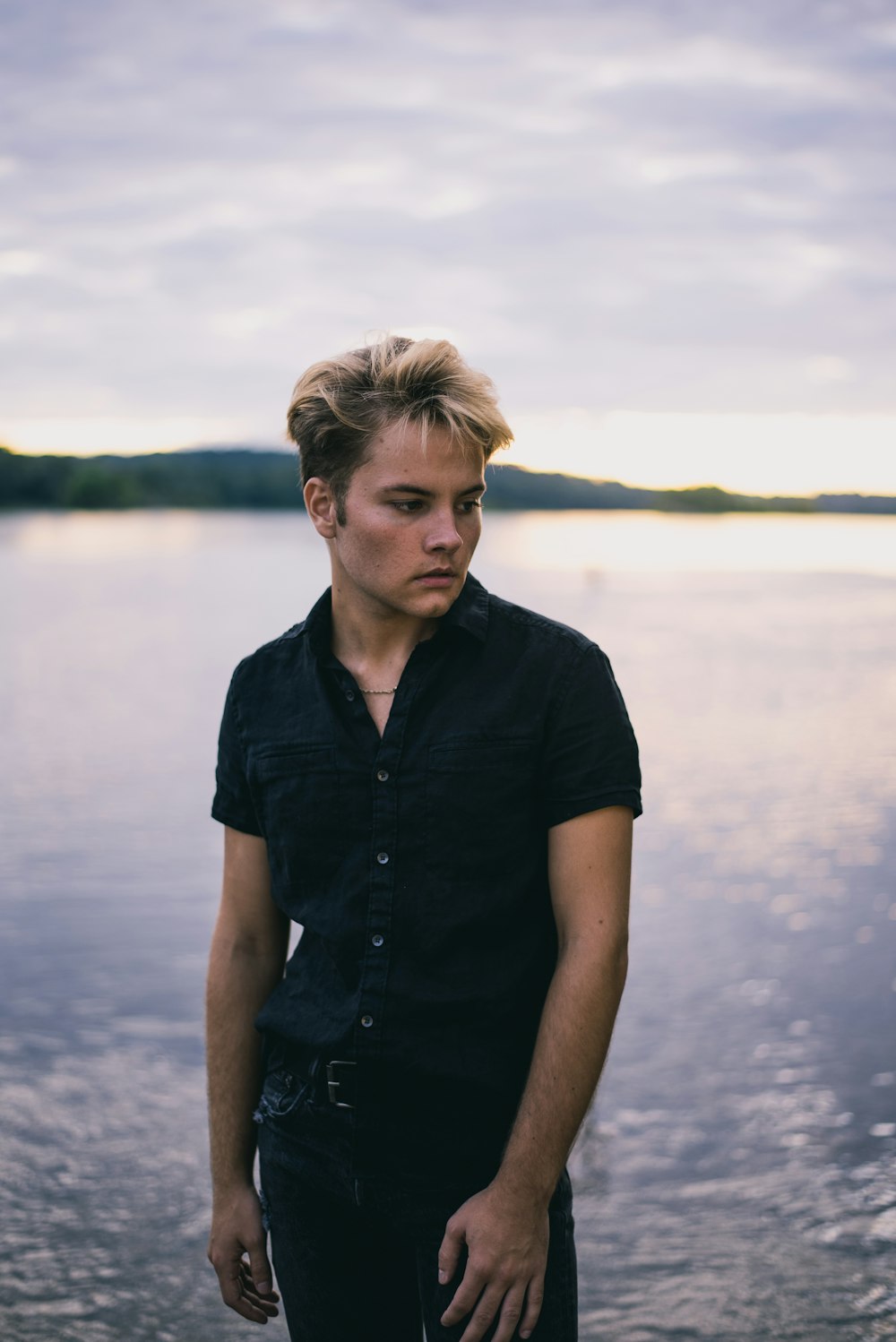 man in black button up shirt standing near body of water during daytime