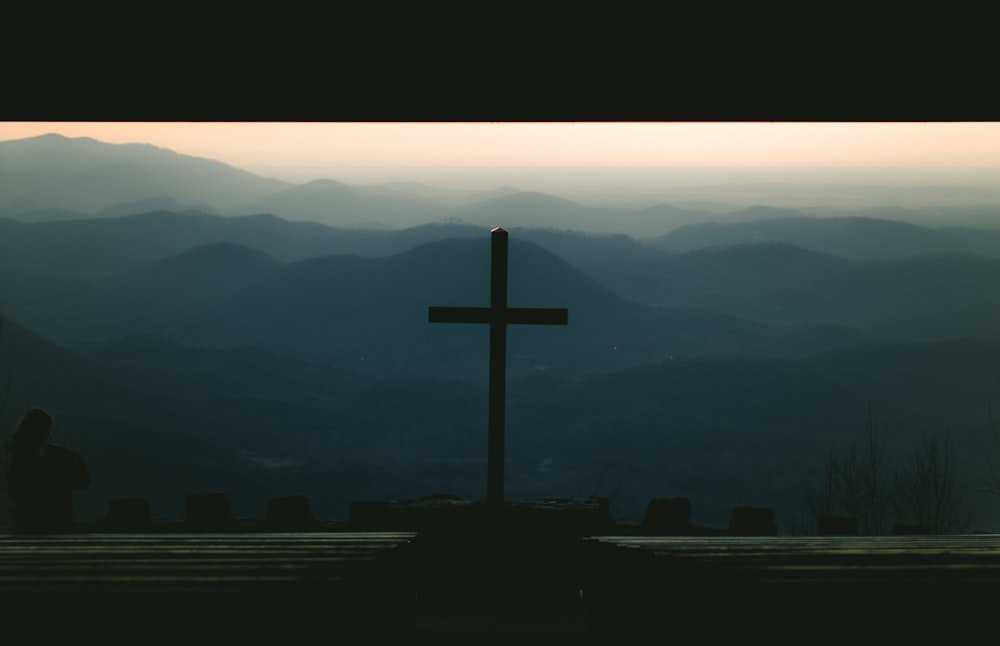 silhouette of cross on top of building during sunset