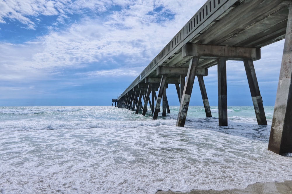 brown wooden dock on sea under blue sky during daytime