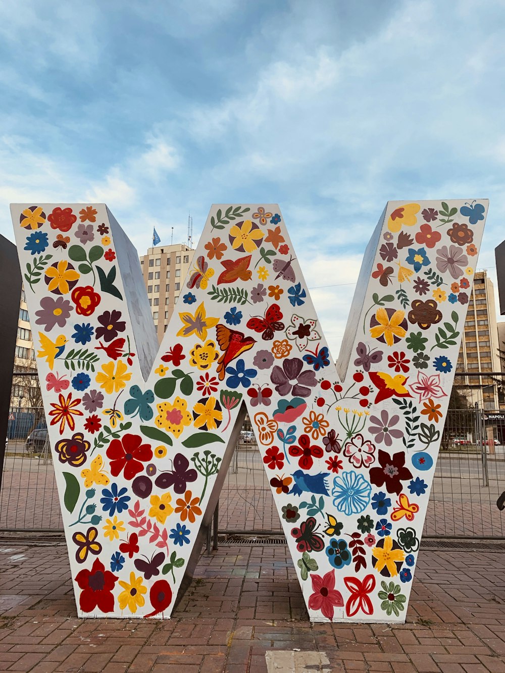 white blue and red floral textile on brown wooden fence