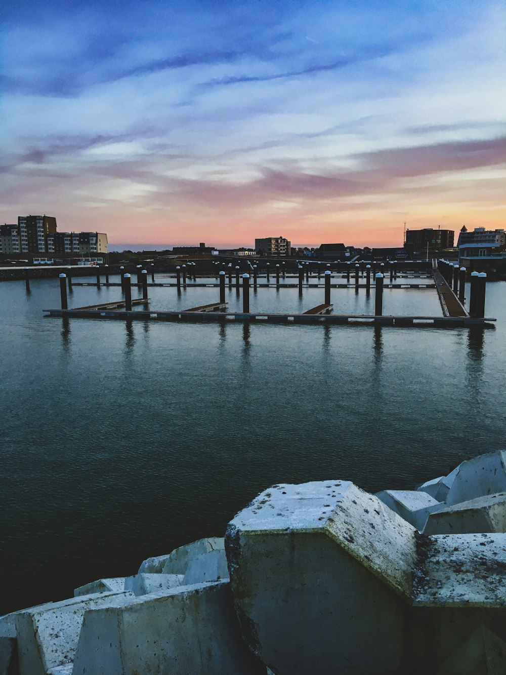 body of water near concrete building during sunset