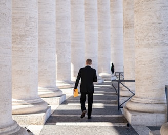man in black suit standing on gray concrete staircase