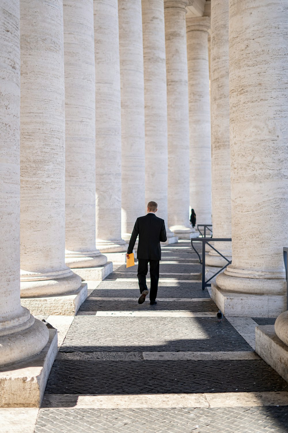 man in black suit standing on gray concrete staircase