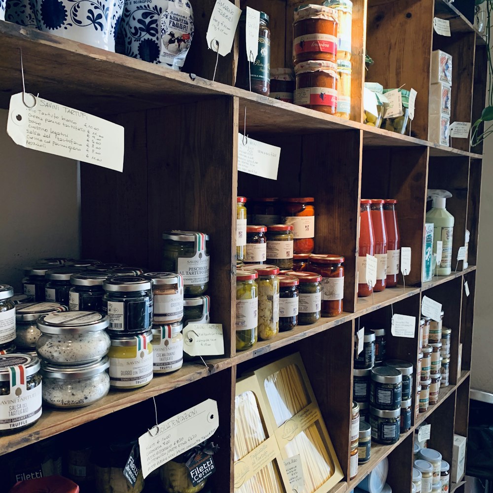 assorted glass jars on brown wooden shelf