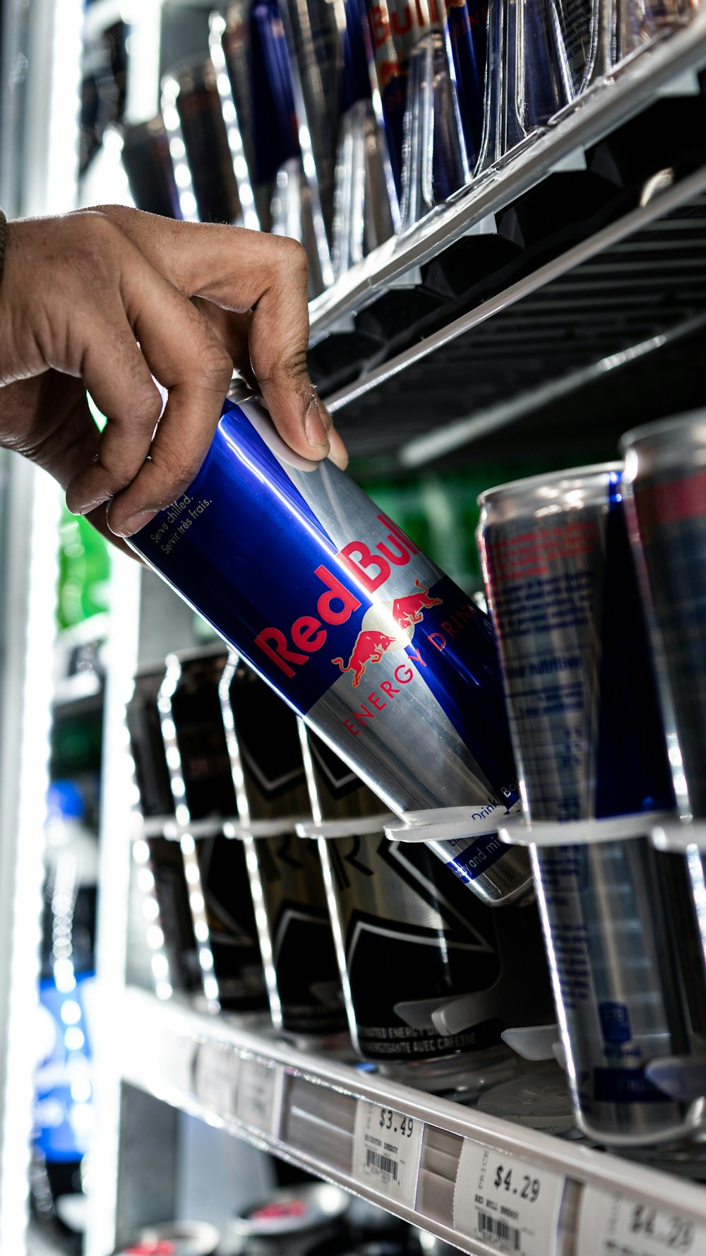 person holding red bull energy drink can