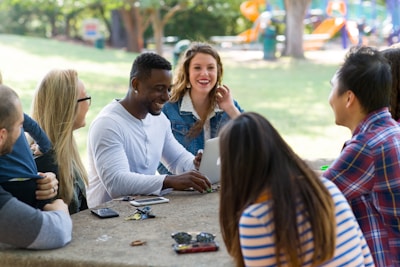 diverse employees sitting outside at a picnic table.