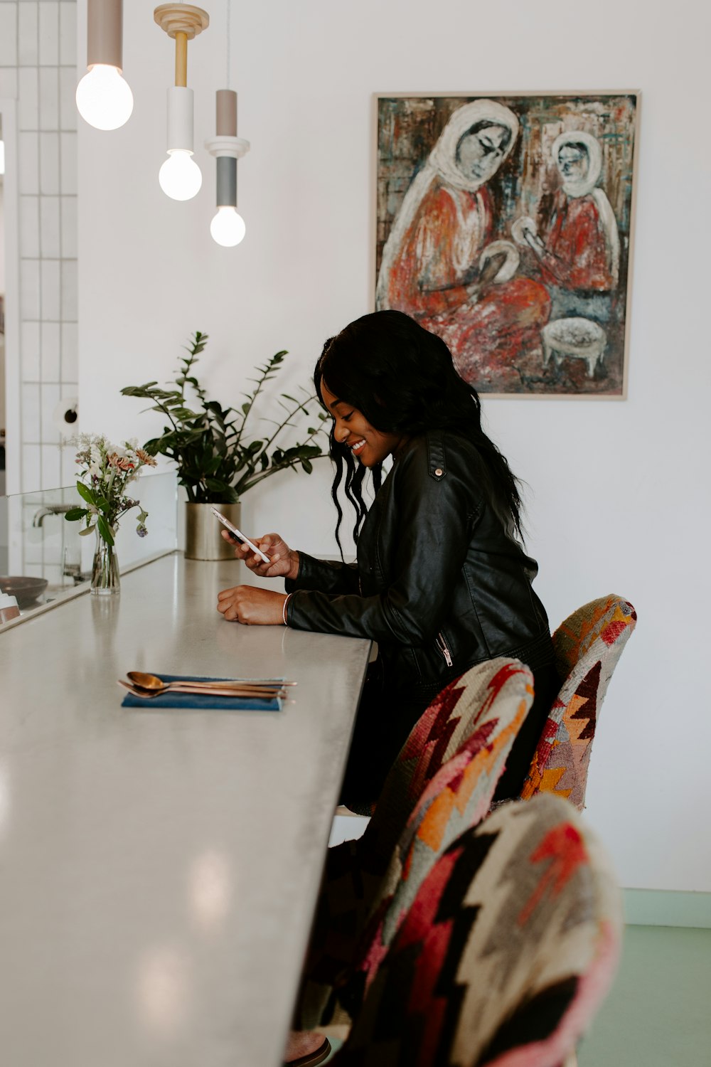 woman in black leather jacket sitting on chair