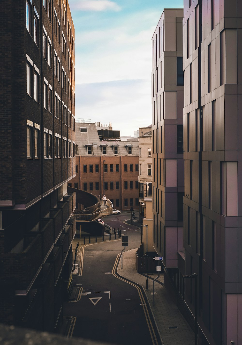 cars parked beside brown concrete building during daytime