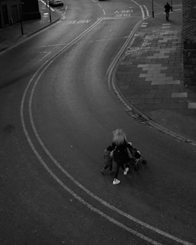 grayscale photo of 2 women walking on road