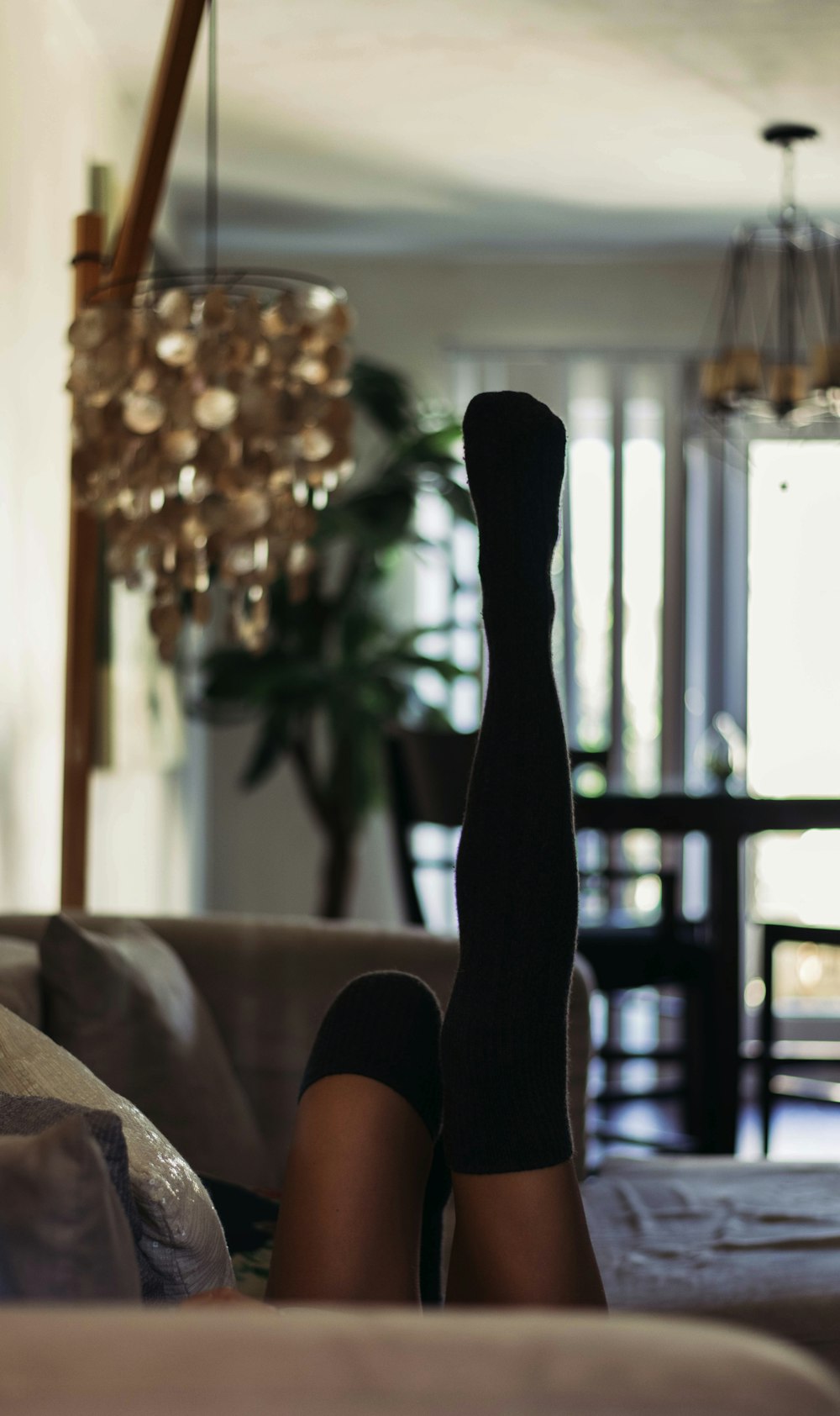 person in black socks lying on white bed