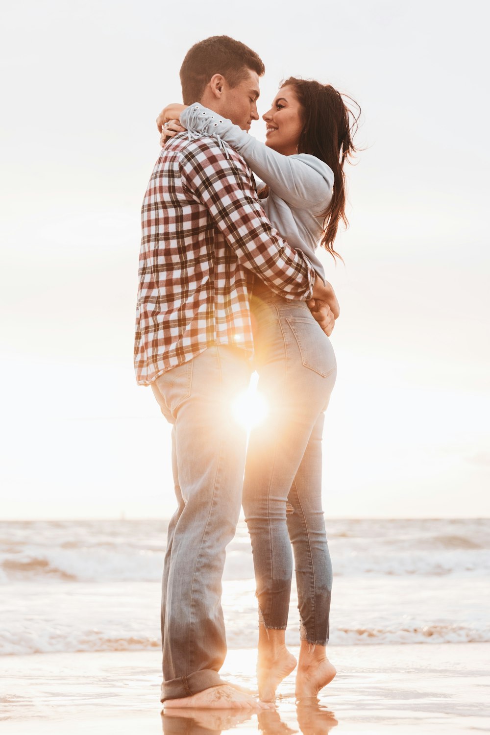 man and woman kissing on beach during daytime