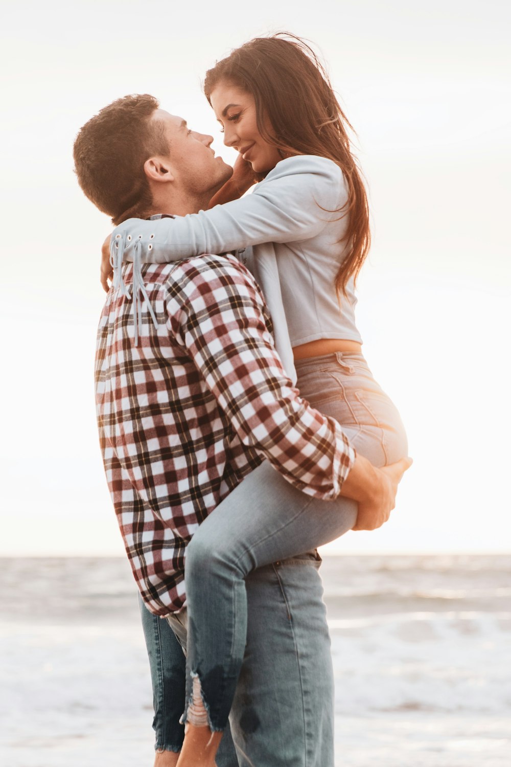 man in white red and black plaid dress shirt kissing woman in white dress shirt on near on near on