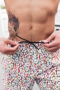 a man with a tattoo on his back holding a string