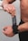 A muscular person adjusting a black wrist strap with the text 'VERSA GRIP PRO' on it. The focus is on the hands and forearms, showcasing the details of the strap. The background is neutral, emphasizing the subject.