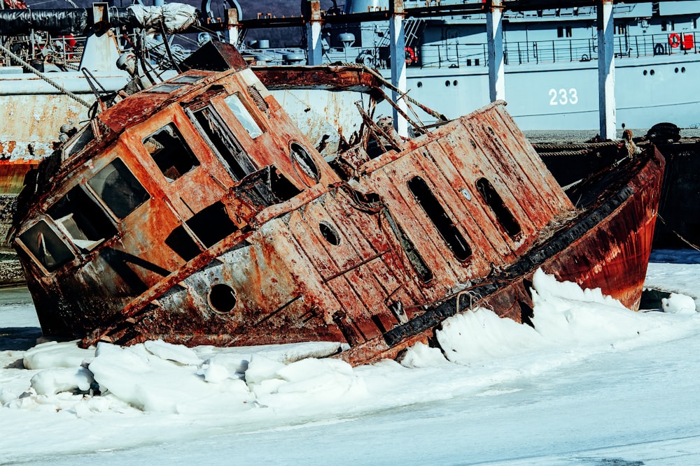 brown and black metal ship on white snow covered ground during daytime