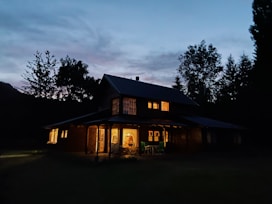 Exterior view of the cozy chalé surrounded by trees at dusk