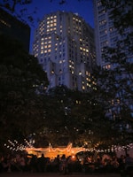 An outdoor evening event illuminated by elegant string lights and focused lamps.
