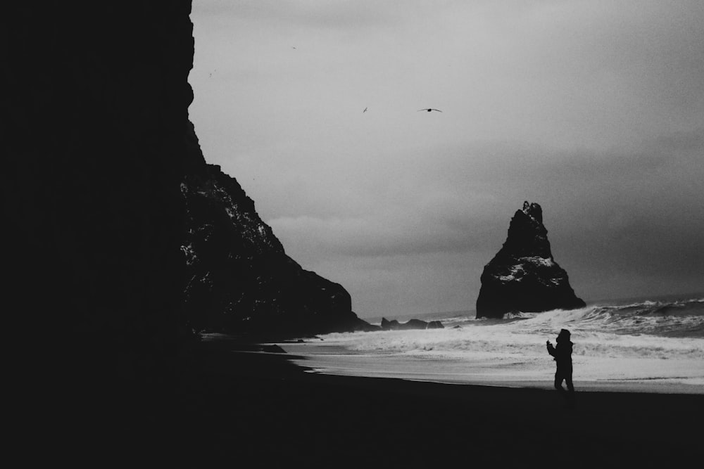 silhouette of 2 people walking on beach shore