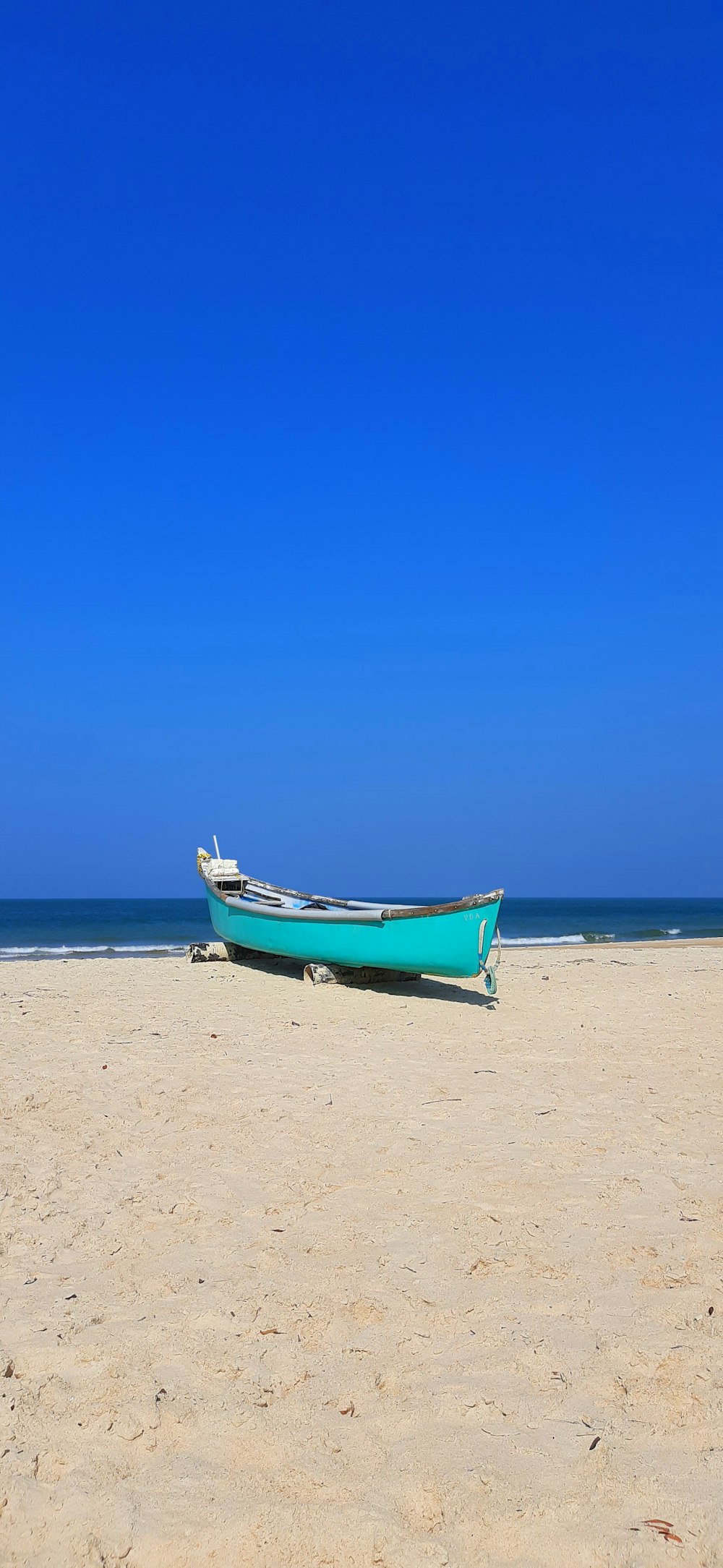 blue and white boat on beach during daytime