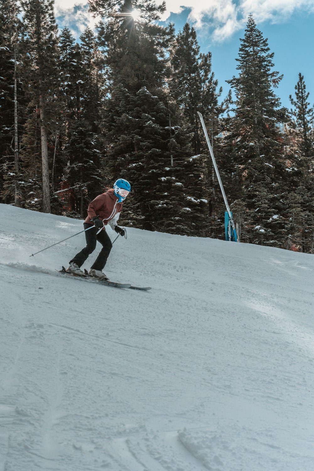 person in red jacket and blue pants riding ski blades on snow covered ground during daytime