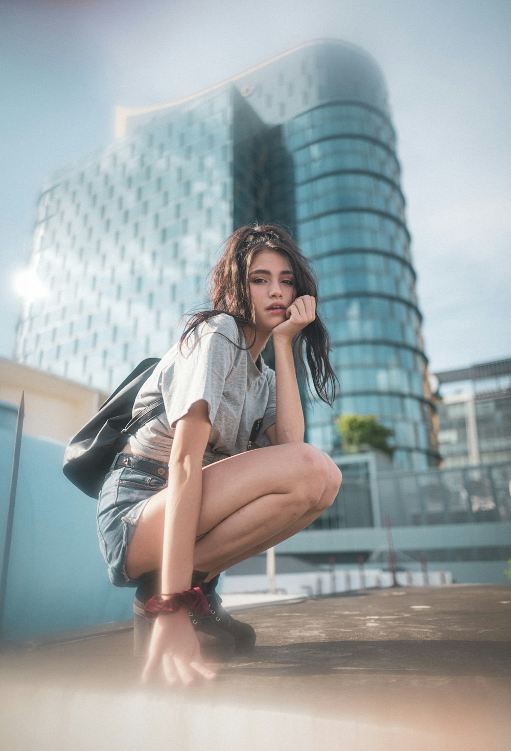 woman in blue denim jacket sitting on red metal pole