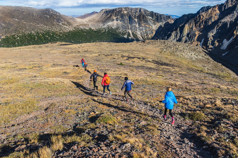 3 people walking on dirt road during daytime