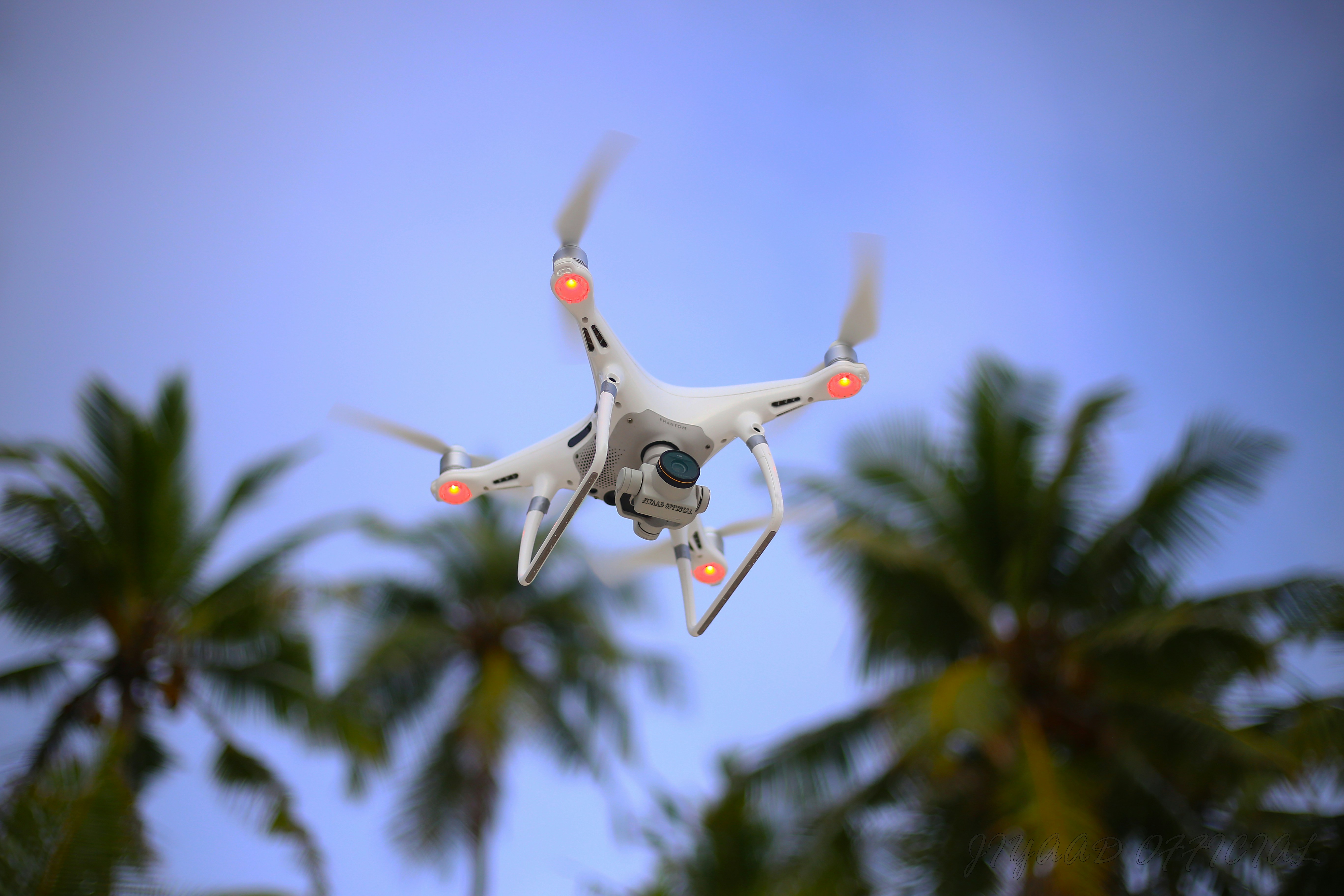 white drone flying in the sky during daytime
