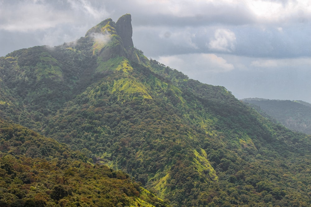 montanha verde e cinza sob nuvens brancas durante o dia