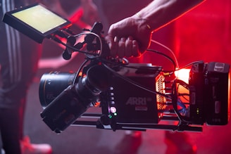 person holding black and red video camera
