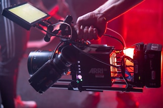 person holding black and red video camera