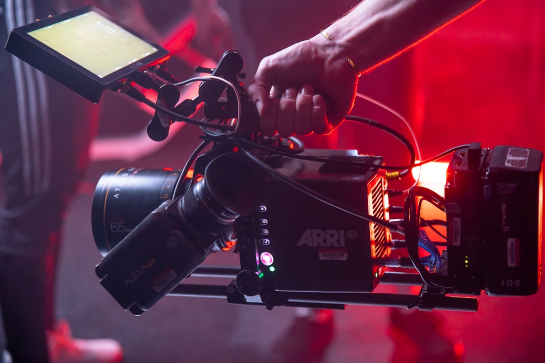 person holding black and red video camera