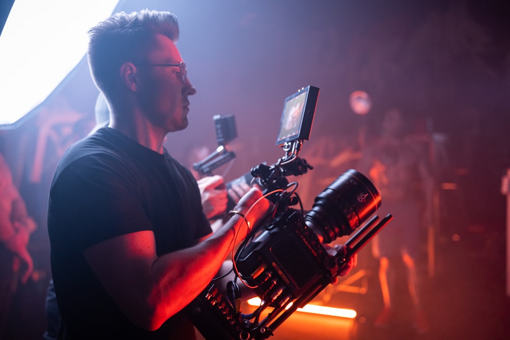 man in black crew neck t-shirt holding black video camera