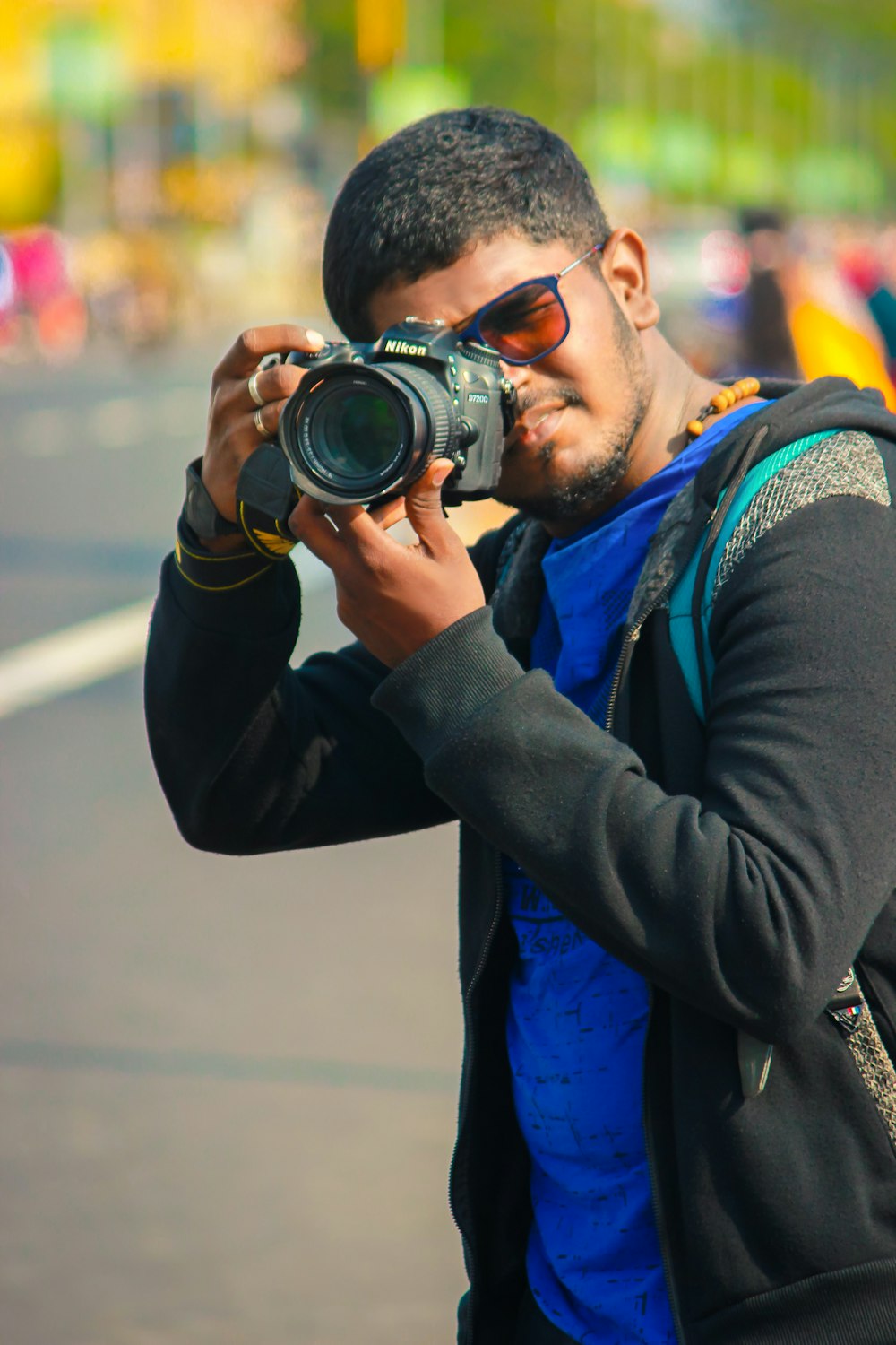 man in black jacket holding black dslr camera